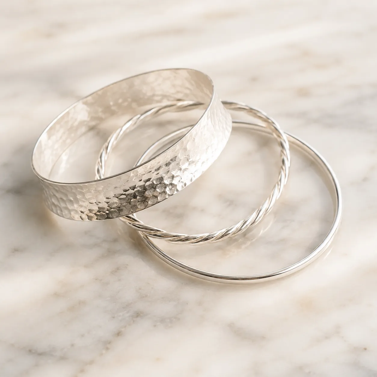 Zilveren bangle armbanden gestapeld – brede gehamerde, gedraaide en gladde bangle in 925 zilver