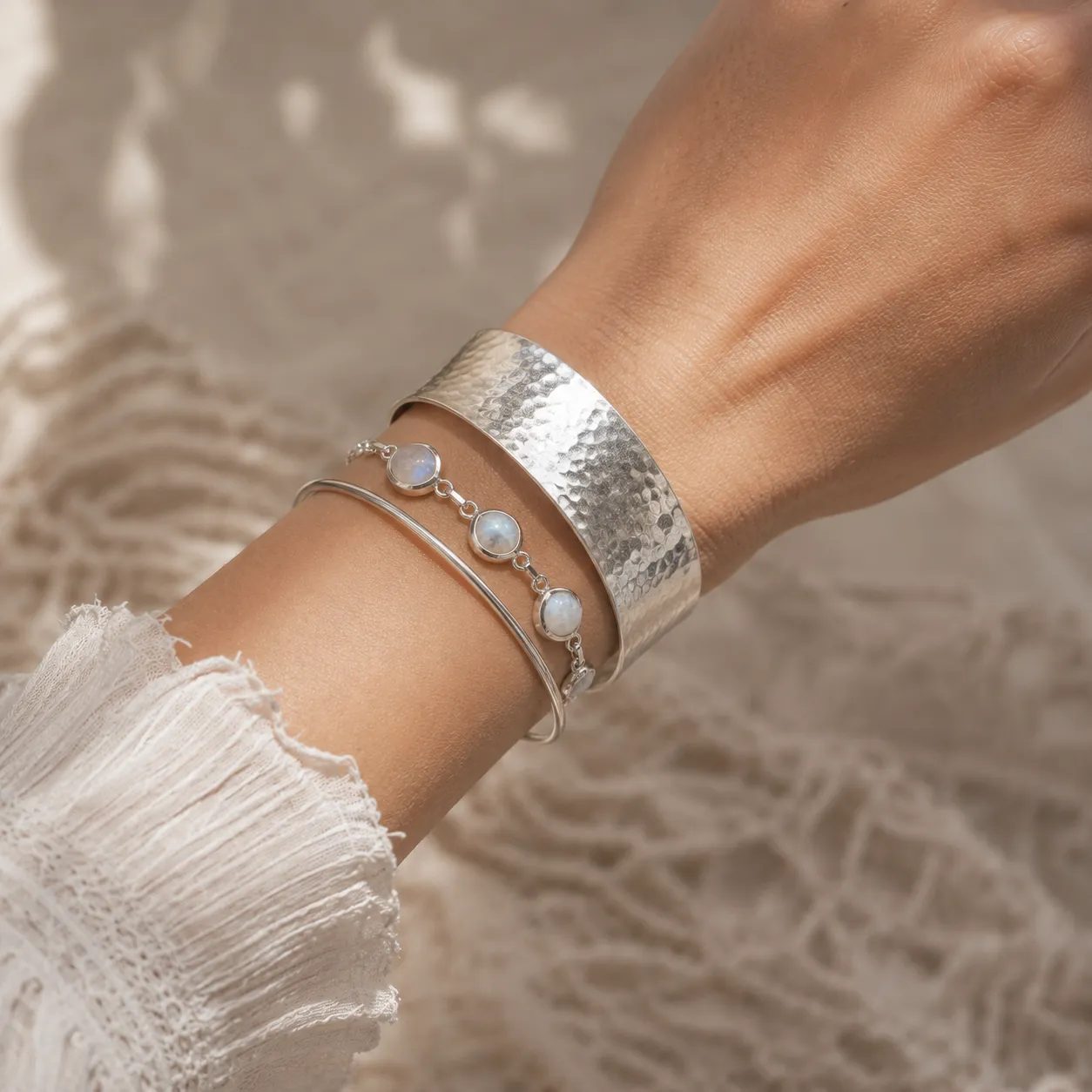 Zilveren armbanden combineren aan de pols – brede gehamerde armband gecombineerd met maansteen armband