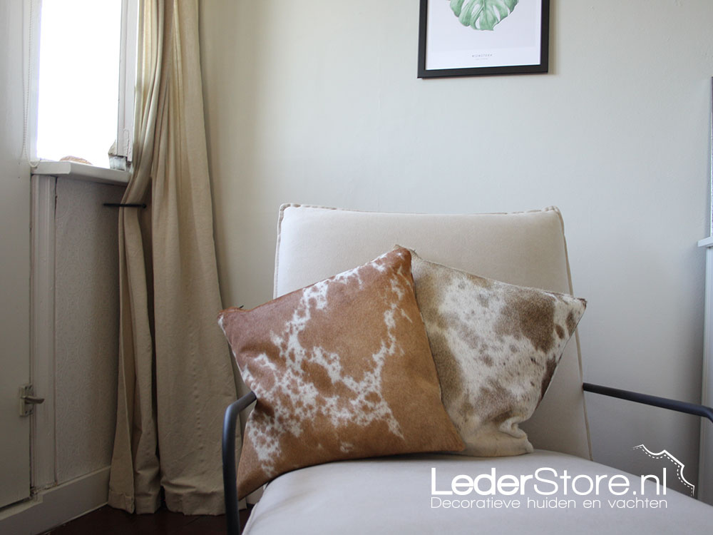 Cowhide cushions brown white on chair in bedroom