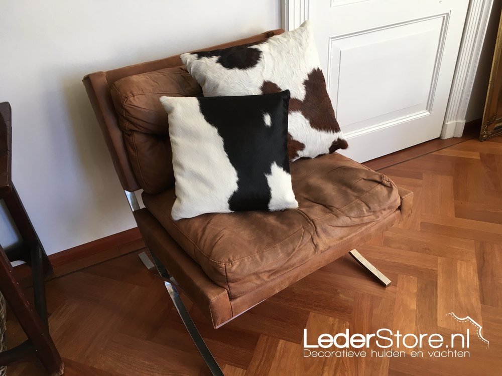 Kissen aus Kuhfell, schwarz-weiß, auf einem Stuhl aus cognacfarbenem Leder 2