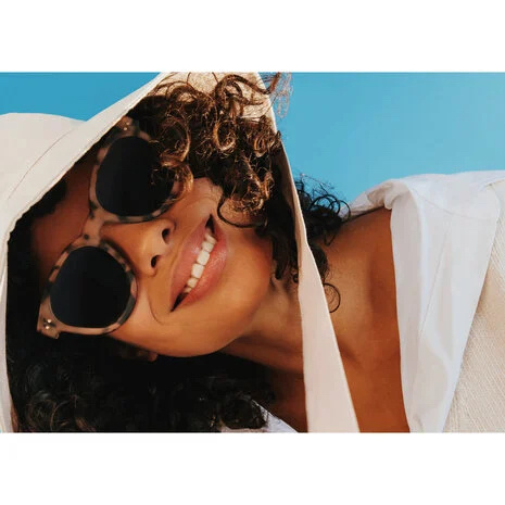 Femme en tenue de vacances avec des lunettes de soleil