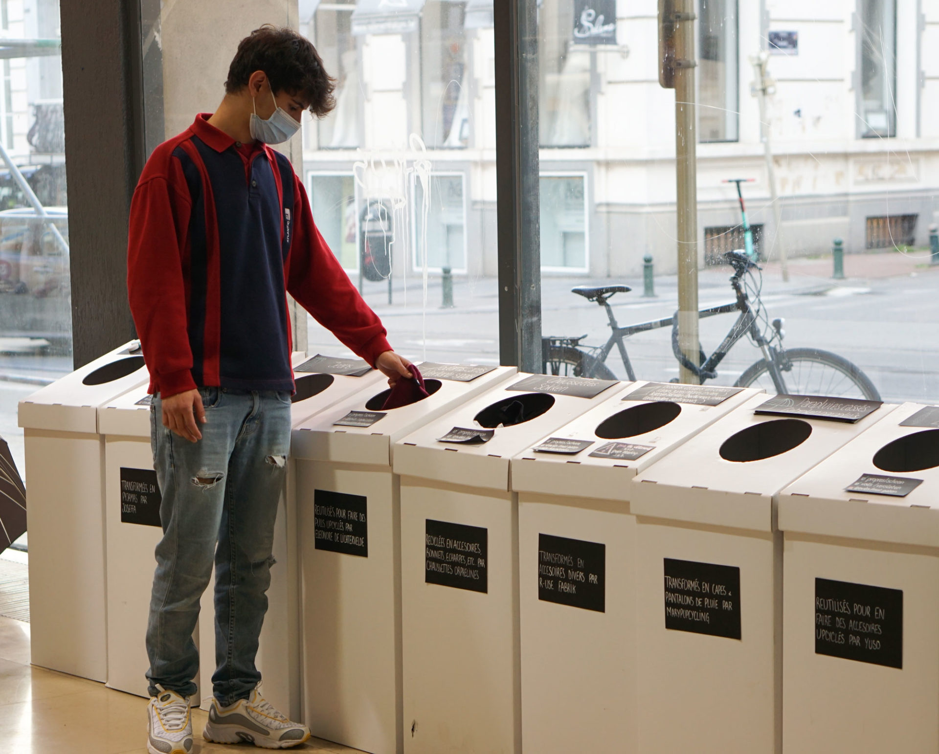 Un jeune homme mettant ses vêtements à recycler