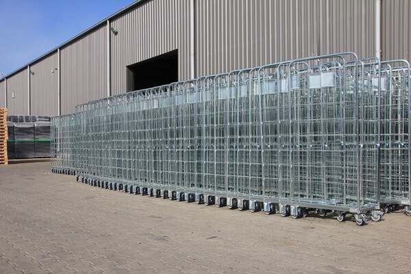 Metalowe wózki gniazdowe składowane na dworze, ułożone kompaktowo w pionowe zestawy