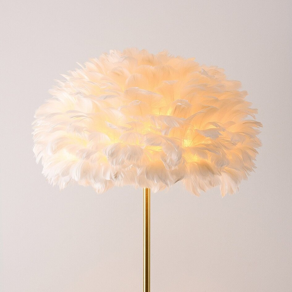 Lampadaire design Evania avec plumes blanches et base en laiton doré