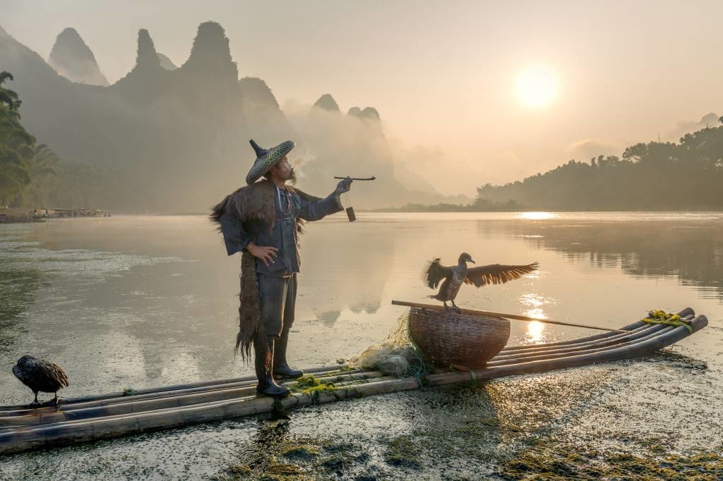 Smokes a pipe at the Li River