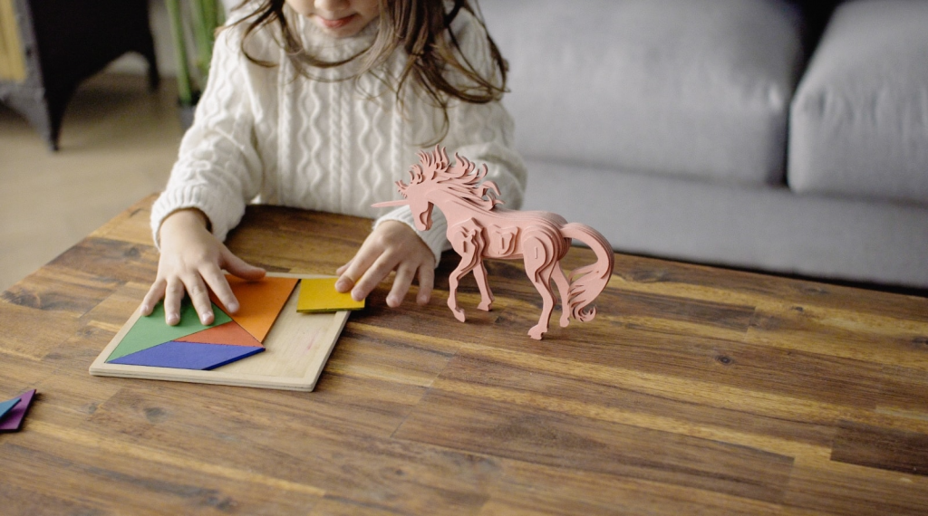 Child playing with a puzzle made with FLUX Beambox.