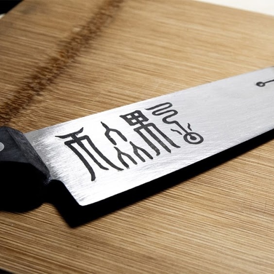 Kitchen knife with symbols engraved on the blade by a FLUX Beambox.