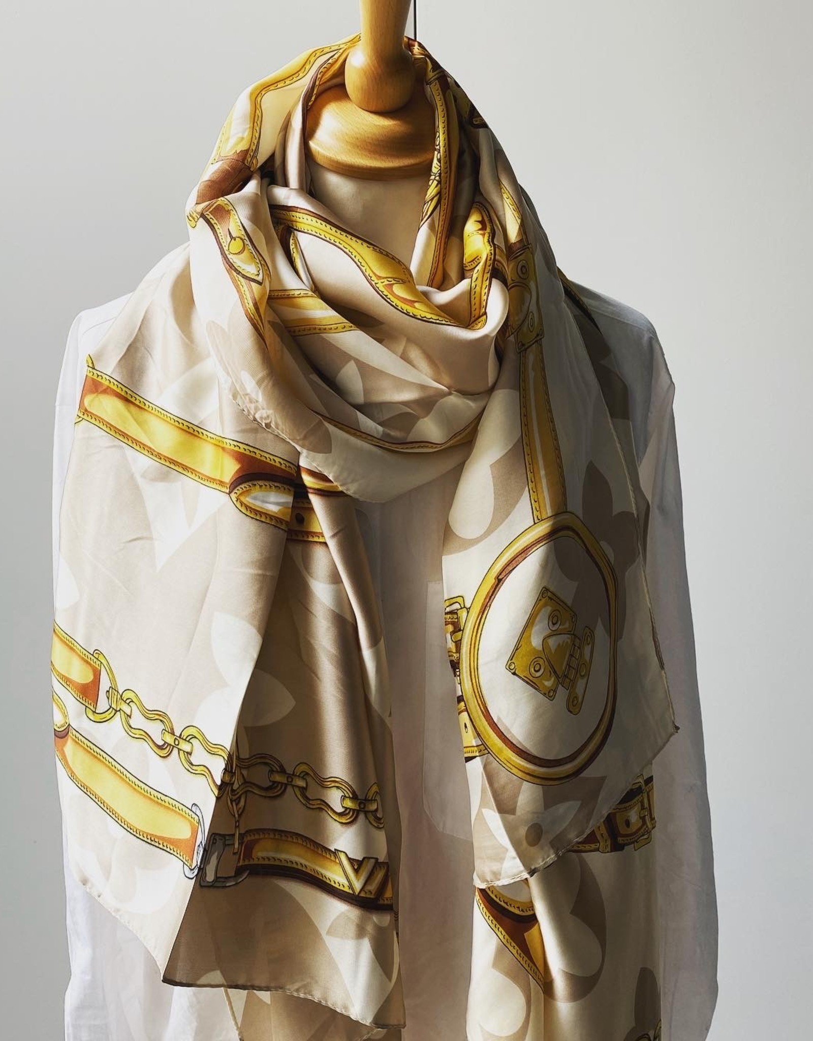 Long scarf with logo in beige colors.