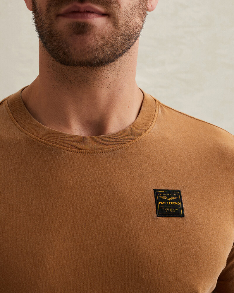 T-shirt avec lavage teint en vêtement et badge jaune T-shirt avec lavage teint en vêtement et badge jaune