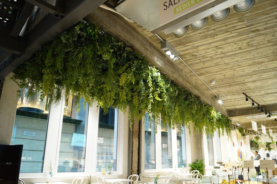 Green ceiling in a long room · ceiling planting · hospitality
