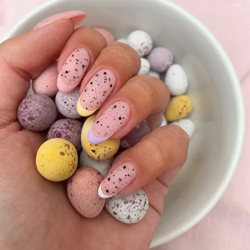 Easter-inspired nails with speckled designs, perfect for a festive look