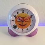 Klokkendiscounter Design - cheerful children's alarm clock with a smiling face.