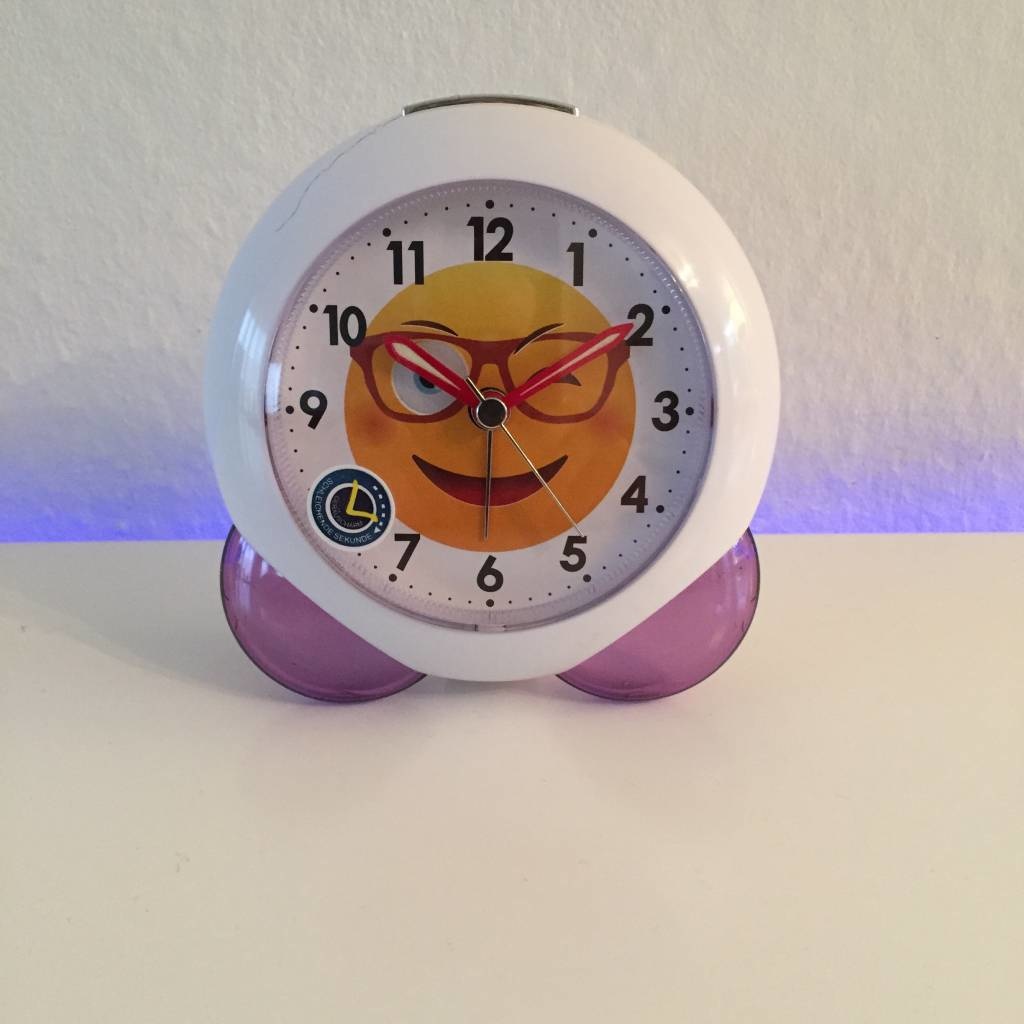 Klokkendiscounter Design - cheerful children's alarm clock with a smiling face.