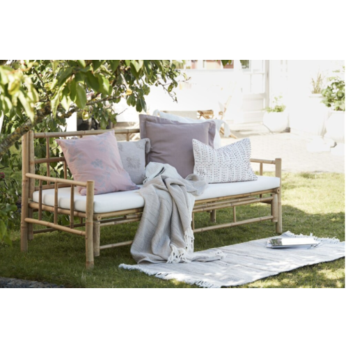 Handmade bamboo couch with a white canvas cushion for both indoor and outdoor use.