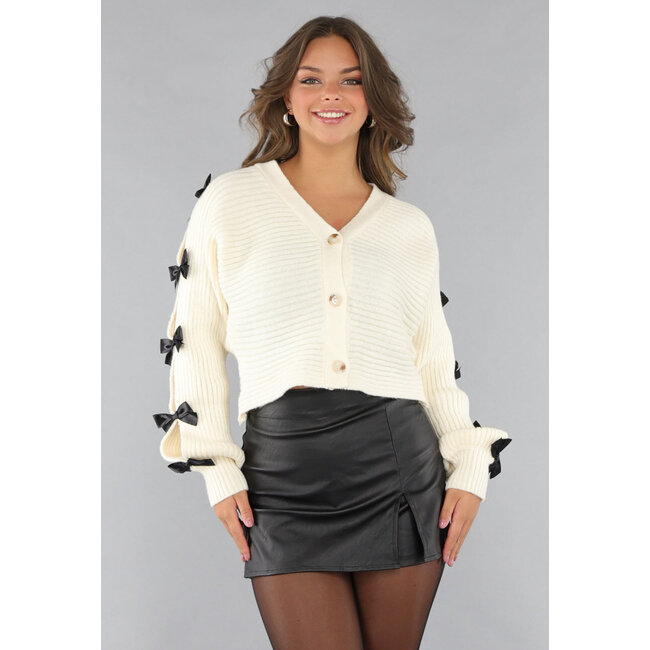 Beigefarbene Strickjacke mit schwarzen Schleifen
