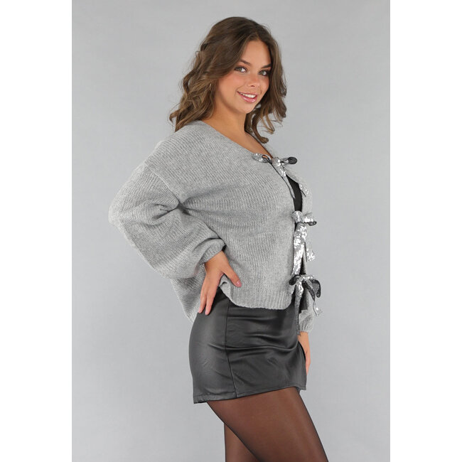Grauer Pullover mit Pailletten-Schleifen