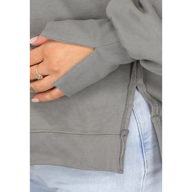 Grauer Pullover mit Schlitzen und ausgefransten Nähten