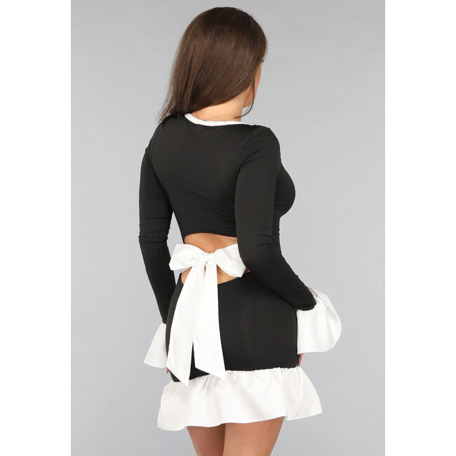 Schwarzes Kleid mit weißen Rüschendetails und Schleife