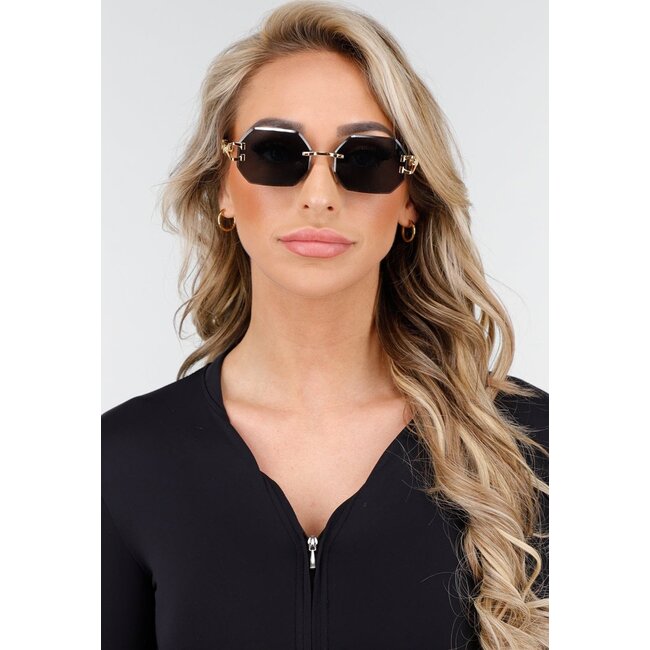 Rahmenlose Sonnenbrille mit geometrischen Gläsern und goldenem Leopardenmuster auf den Beinen