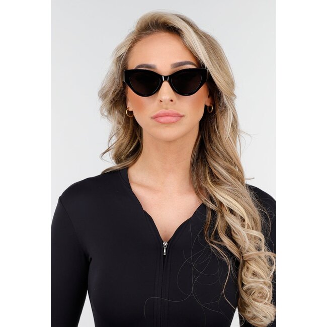 Mattschwarze Sonnenbrille mit breiten Beinen, dunkle Gläser und helles Cat-Eye-Modell