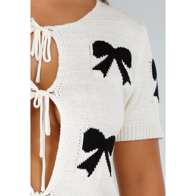 Cremefarbenes Strickoberteil mit schwarzem Schleifenaufdruck, Stretch und Bündchen an Ärmel und Unterteil