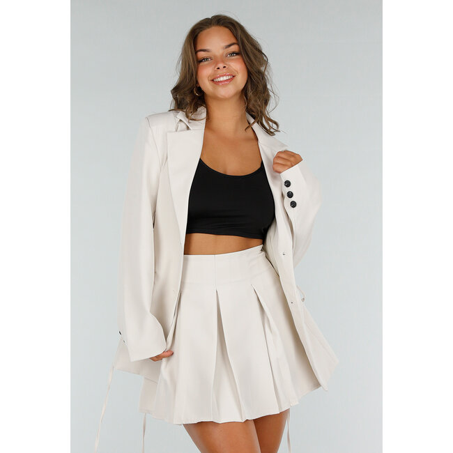 Zweiteiliges Set in Creme mit Korsettblazer und Faltenrock mit Reißverschluss