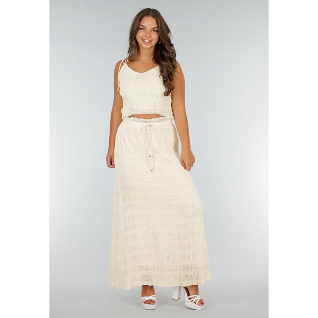 Zweiteiliges cremefarbenes Stretch-Set mit plissiertem Croptop und hochtailliertem Maxirock