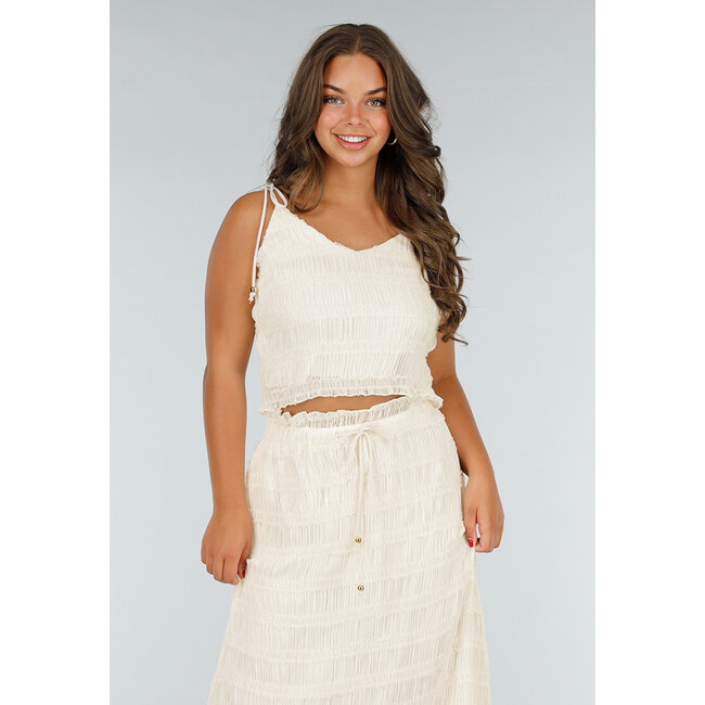 Zweiteiliges cremefarbenes Stretch-Set mit plissiertem Croptop und hochtailliertem Maxirock