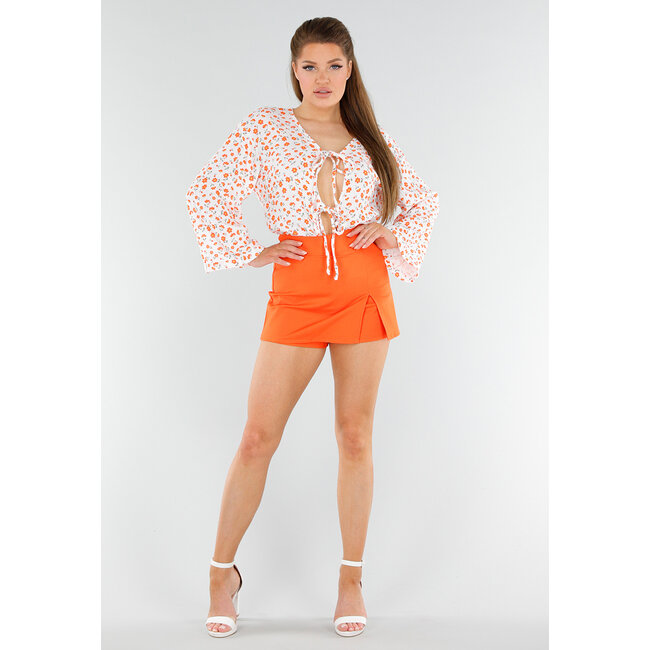 Weiße Bluse mit orangefarbenem Blumendruck und Schleife vorne