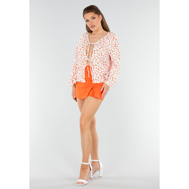 Weiße Bluse mit orangefarbenem Blumendruck und Schleife vorne