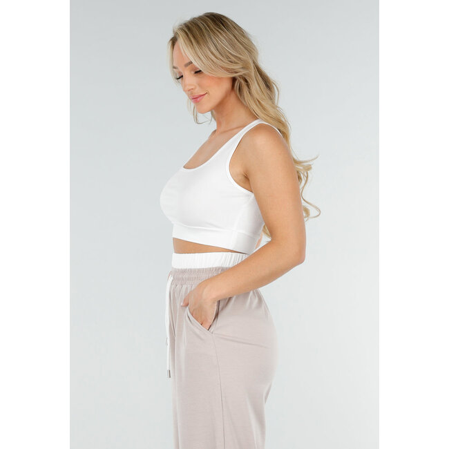 Weißes Crop-Top und beigefarbene weite Hose mit Gummizug in der Taille