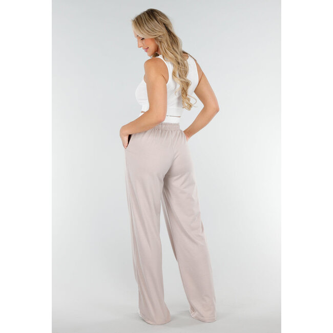 Weißes Crop-Top und beigefarbene weite Hose mit Gummizug in der Taille