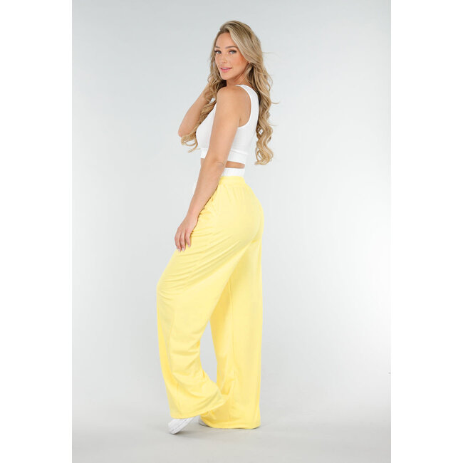 Weißes Crop-Top und buttergelbe weite Hose mit Gummizug am Bund