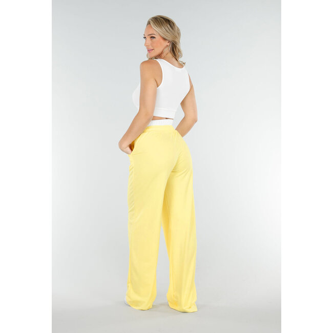 Weißes Crop-Top und buttergelbe weite Hose mit Gummizug am Bund