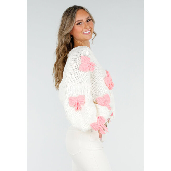 Gestrickte Strickjacke in Creme mit rosa Schleifen