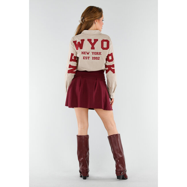 Beigefarbene Bluse mit rotem NY-Aufnäher und Knopfverschluss