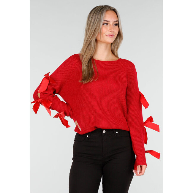 Roter Strickpullover mit Schleifen an den Ärmeln
