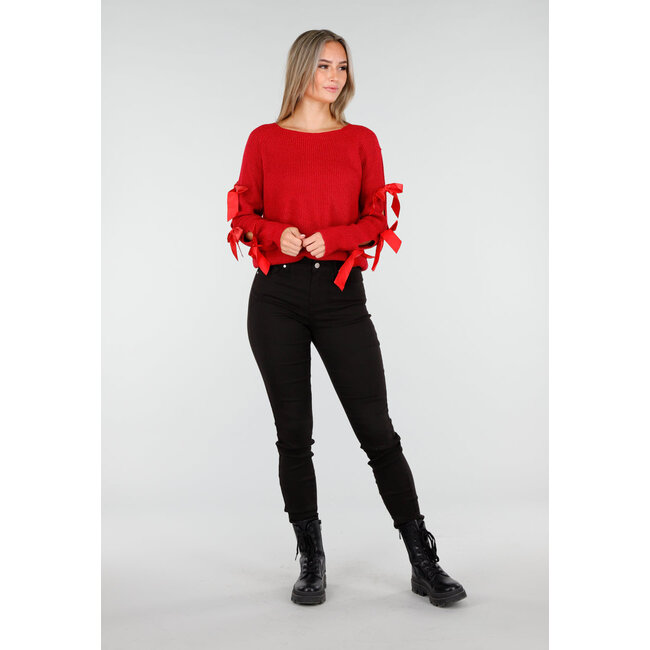 Roter Strickpullover mit Schleifen an den Ärmeln