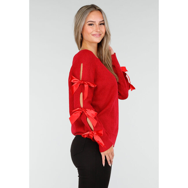 Roter Strickpullover mit Schleifen an den Ärmeln