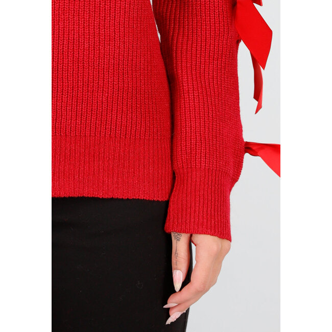 Roter Strickpullover mit Schleifen an den Ärmeln