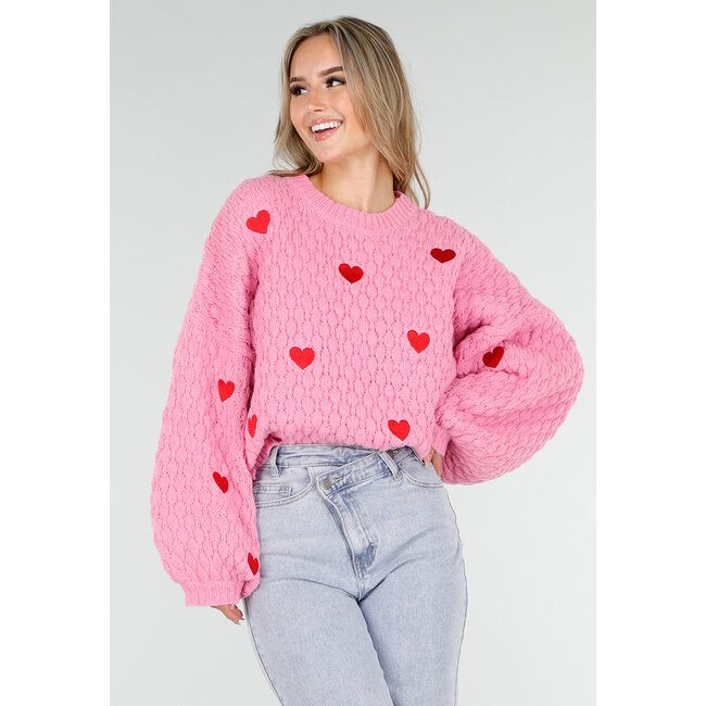 Rosa Strickpullover mit roten Herzen und weiten Ärmeln