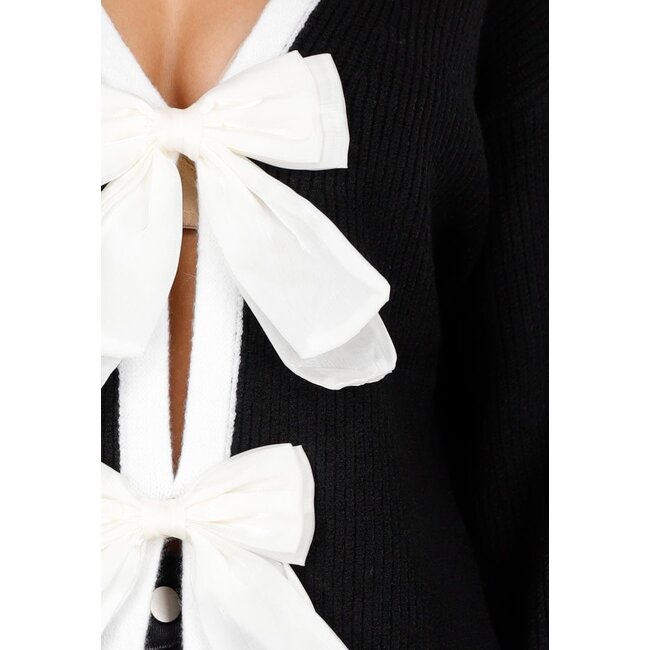 Schwarze Strickjacke mit weißer Schleifenverschluss und langen Ärmeln
