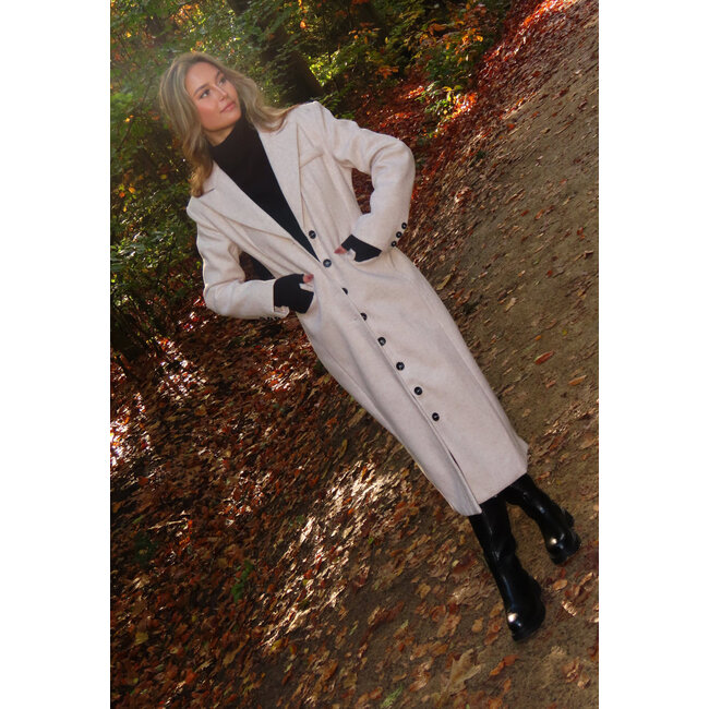 Langer beiger Mantel mit schwarzen Knöpfen und Pattentaschen