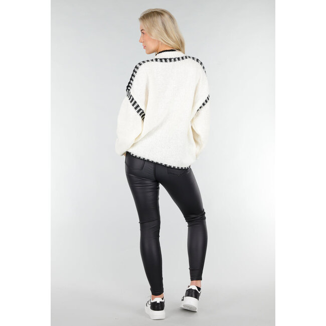 Cremefarbener Strickpullover mit hohem Kragen und schwarzen Randdetails