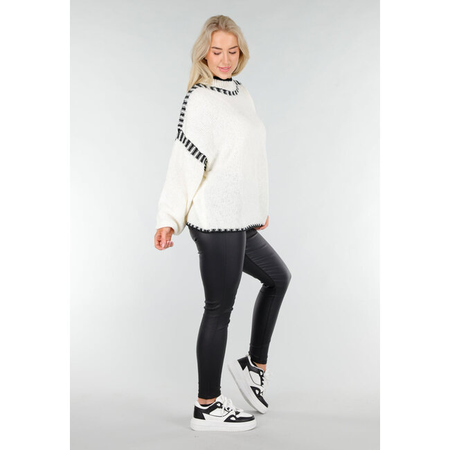 Cremefarbener Strickpullover mit hohem Kragen und schwarzen Randdetails