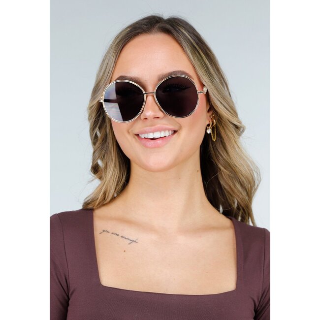 Goldfarbene runde Sonnenbrille mit dunklen Gläsern