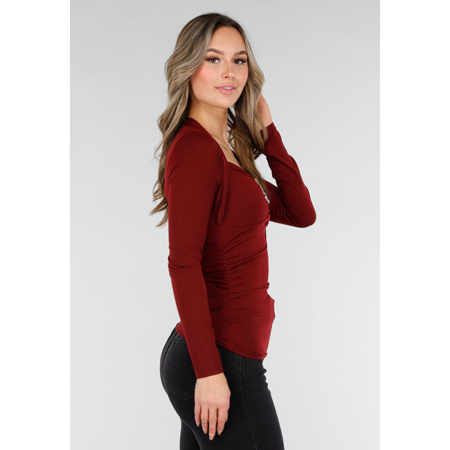 Bordeauxrotes Oberteil mit langen Ärmeln und goldenem Ringdetail