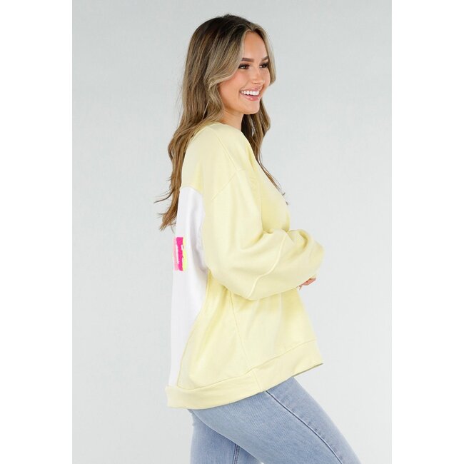 Gelber Pullover mit Good Vibes-Aufdruck auf dem Rücken