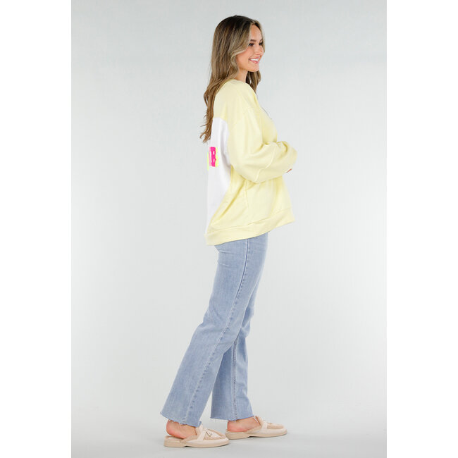 Gelber Pullover mit Good Vibes-Aufdruck auf dem Rücken