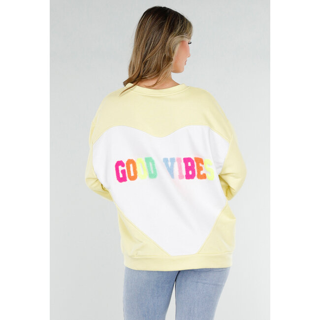 Gelber Pullover mit Good Vibes-Aufdruck auf dem Rücken